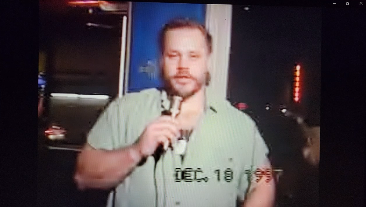 Still frame of Michael Lee Goetz, Sr. hosting THE HOMETOWN Global Open Mic at The Harder Bar, December 1997